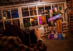 Twee personen met bord “Vrijwilligers, bedankt!” tijdens een feestelijke bijeenkomst.
