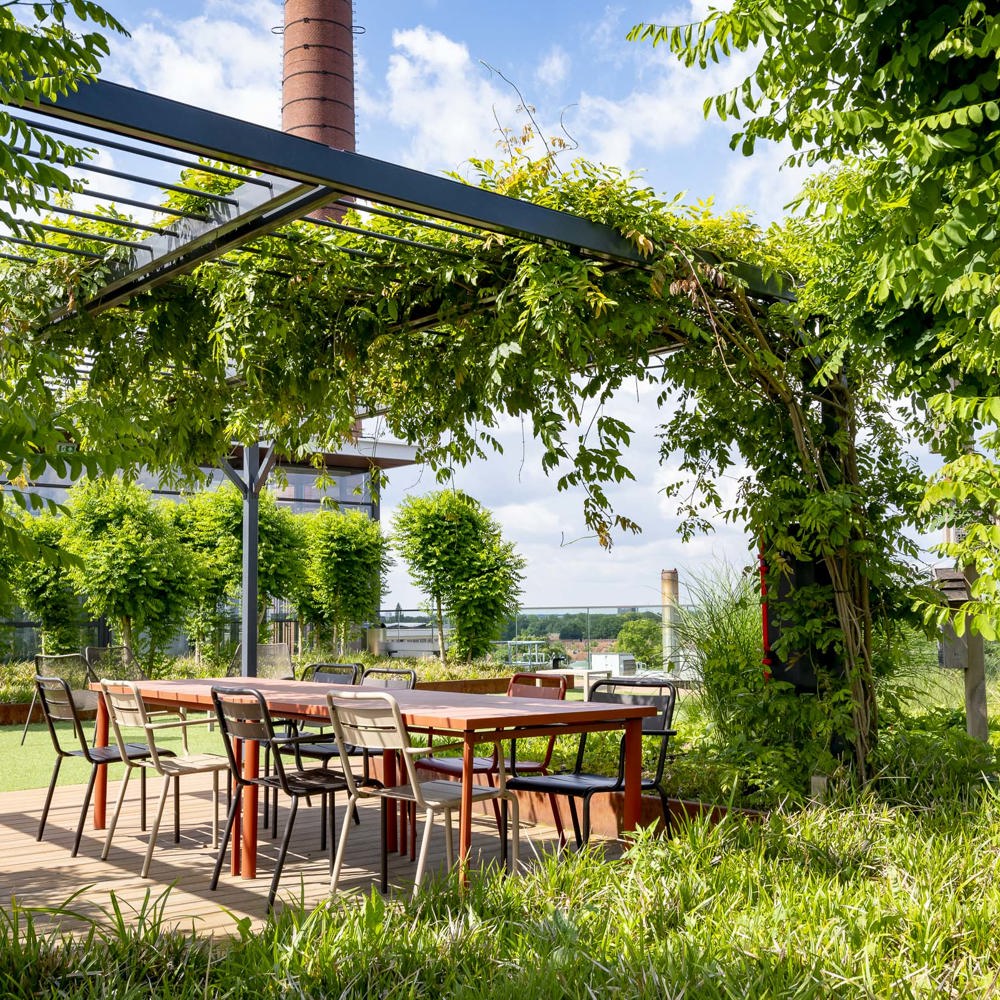 terras met tafel en stoelen met een groene overkapping