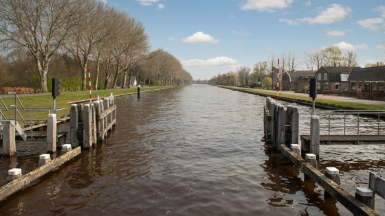 foto van sloot met roodwitte balkjes