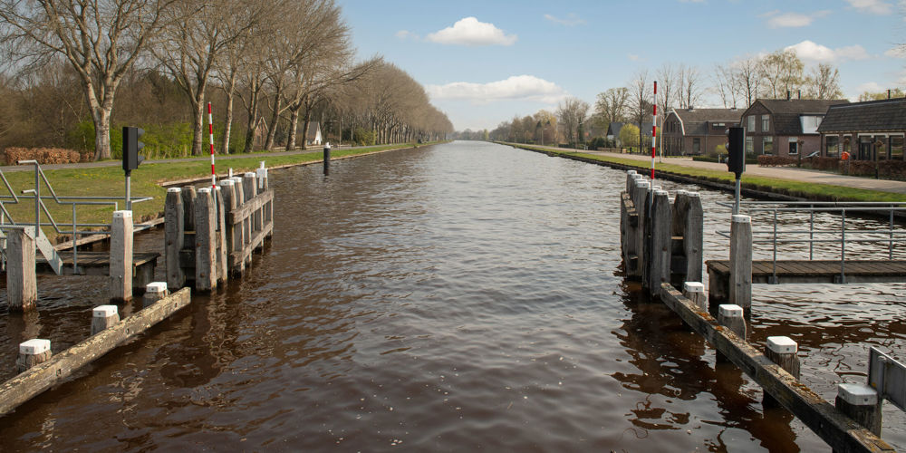 foto van sloot met roodwitte balkjes