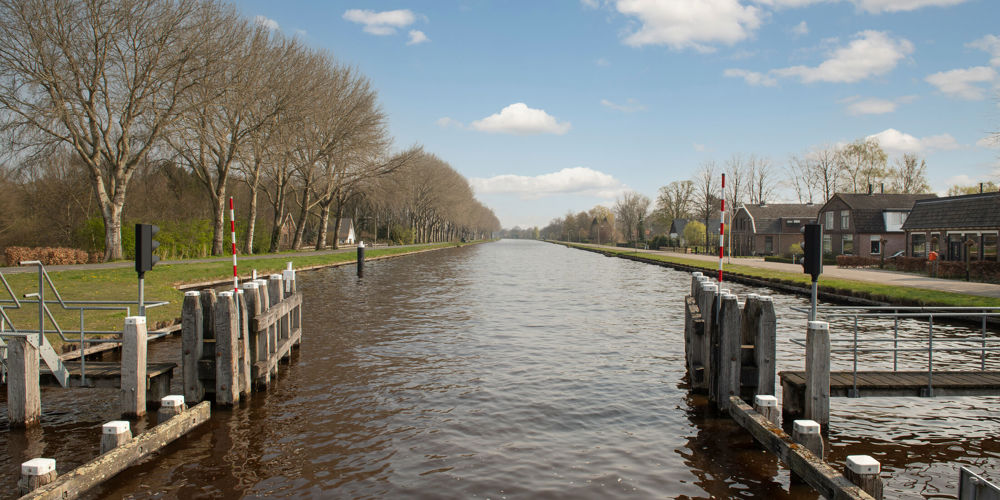 foto van sloot met roodwitte balkjes