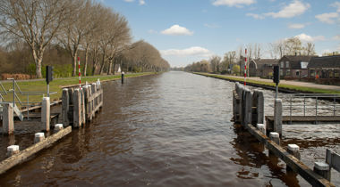 foto van sloot met roodwitte balkjes