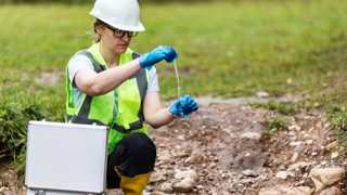 Onderzoeker neemt monsters van de bodem.