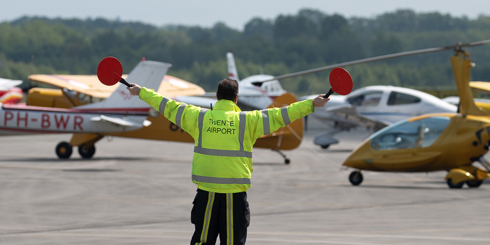 Vliegverkeer begeleider geeft richting op vliegveld