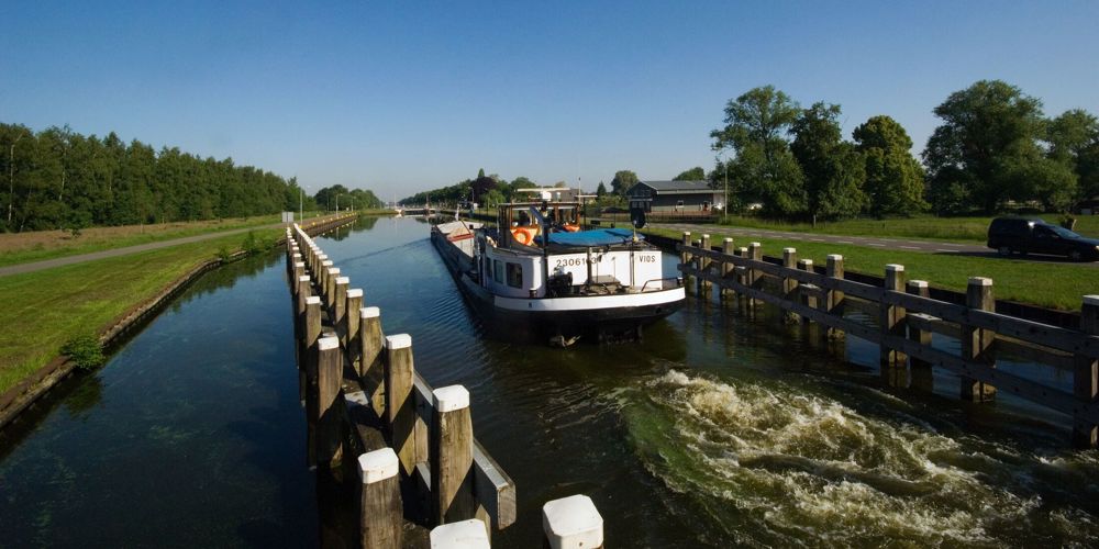 Foto van sloot met boot langs de wegen