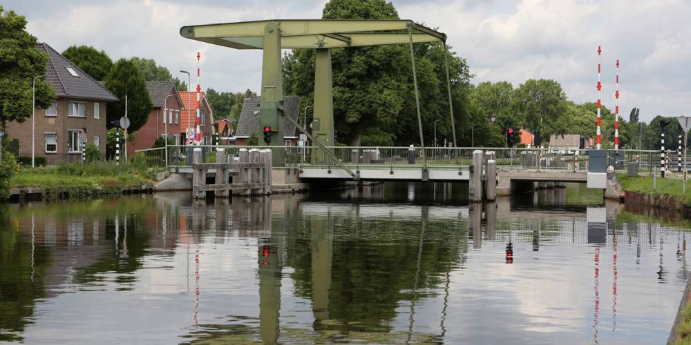 Brug Daarlerveen vanaf de oever gefotografeerd onder een bewolkte lucht.
