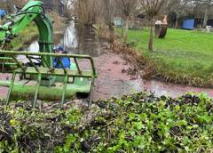 Amfibievoertuig verwijdert waterplanten uit een sloot