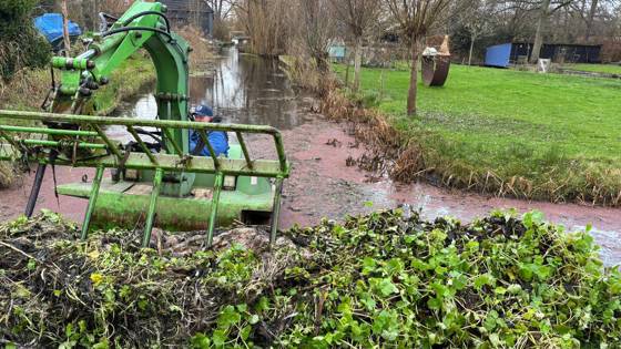 Amfibievoertuig verwijdert waterplanten uit een sloot
