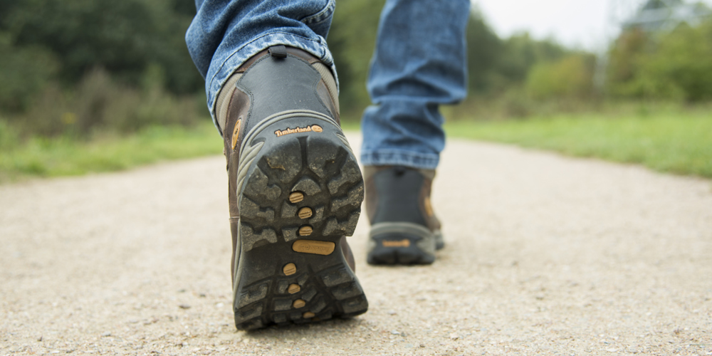 Voeten die wandelen op een looppad in een groene omgeving