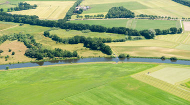 vogelperspectief van landschap van struiken en bomen met een rivier erdoor 