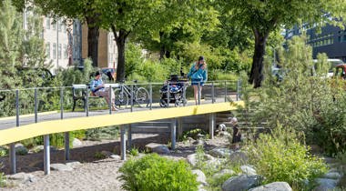 foto van mensen op brug tussen gebouwen in de zon