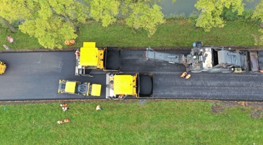 Foto van bovenaf genomen van het asfalteren van een wegdek 