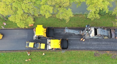 Foto van bovenaf genomen van het asfalteren van een wegdek 