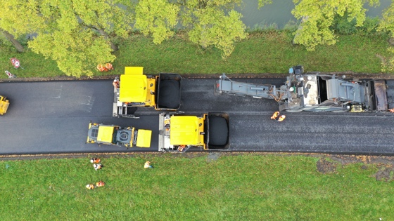 Foto van bovenaf genomen van het asfalteren van een wegdek 