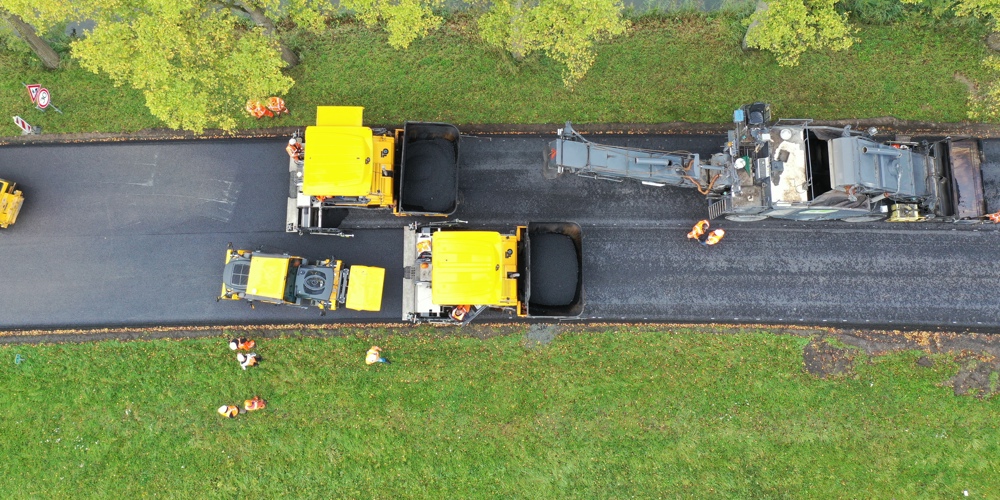 Foto van bovenaf genomen van het asfalteren van een wegdek 