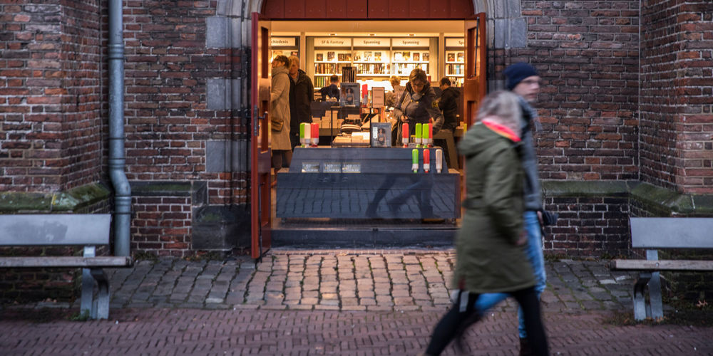 Waanders boekenwinkel Zwolle centrum, vol met mensen en op de voorgrond twee voorbijgangers