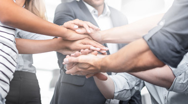 Mensen die hun handen op elkaar stapelen voor een groepshighfive