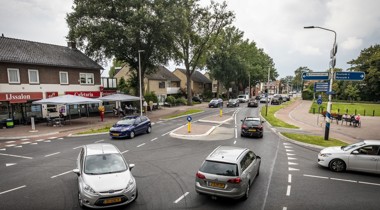 Auto's op een kruispunt in Weerselo (IJssalon op de hoek, rij huizen daarnaast)