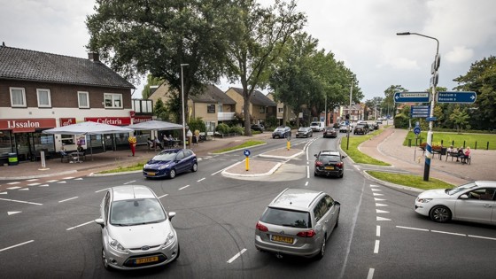 Auto's op een kruispunt in Weerselo (IJssalon op de hoek, rij huizen daarnaast)