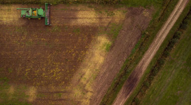 tractor in veld maait weiland foto van bovenaf