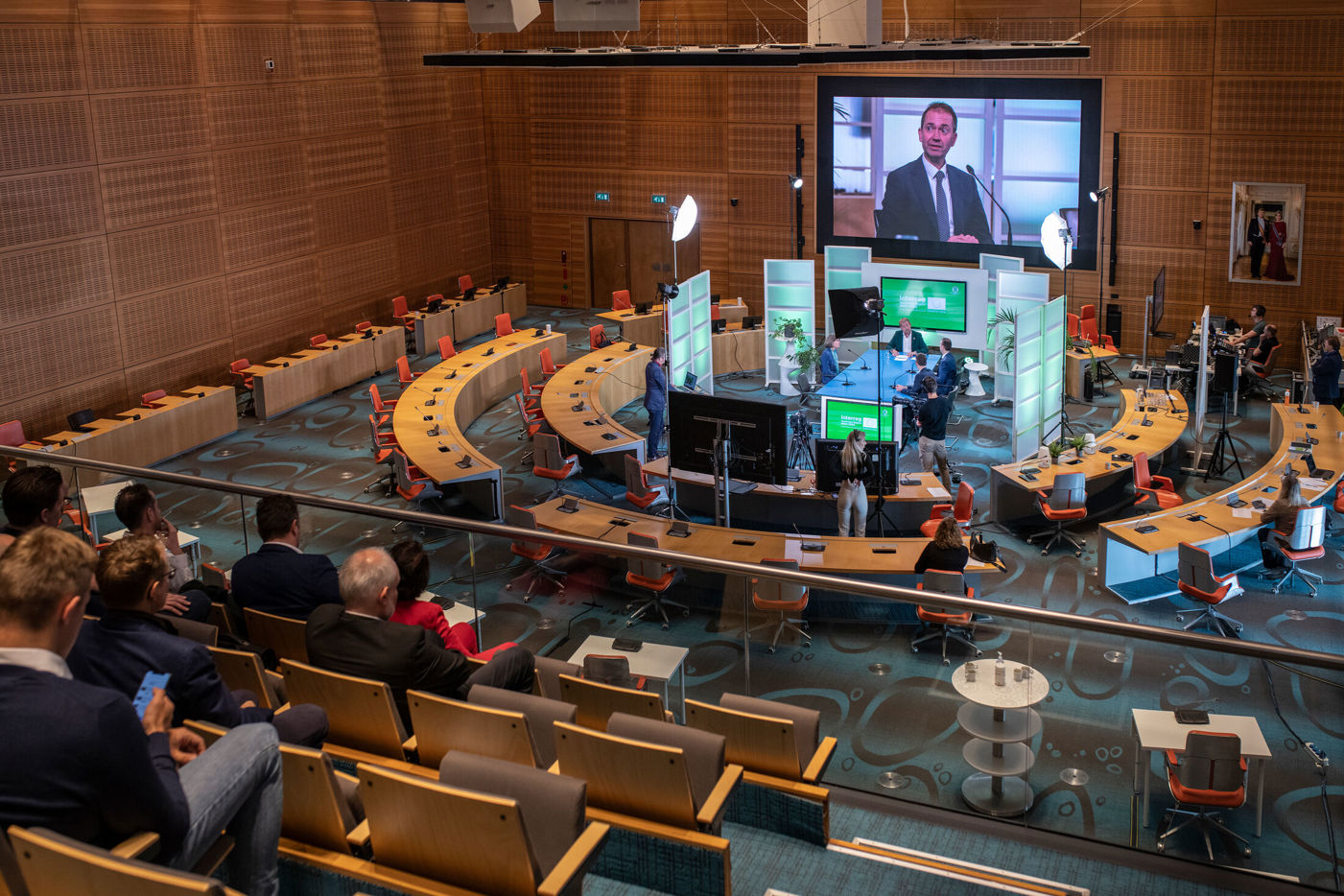 Statenzaal met podcast of talkshow studio in het midden en een gevuld publiek