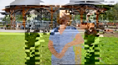 Simone Koggel bij een paaltje met daarachter koeien bij een 'stal'