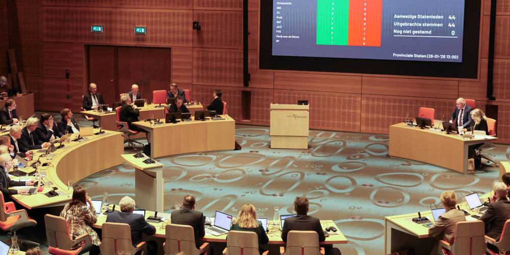 Overzicht van de Statenzaal met stemuitslag op groot scherm.