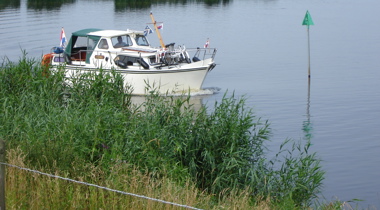 boot op een groot meer langs groene oever