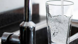 water stroomt uit de kraan in een glas