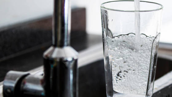 water stroomt uit de kraan in een glas