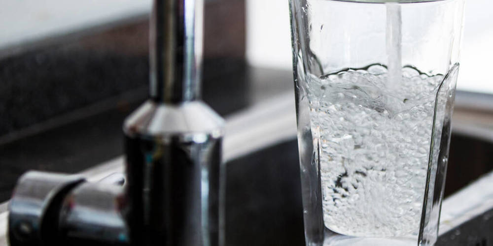 water stroomt uit de kraan in een glas