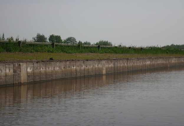 Luchtfoto van plaatsen damwand en daarna een foto van de damwand vanaf het water