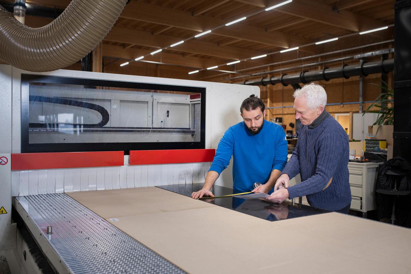 Twee mannen staan aan een grote machine.