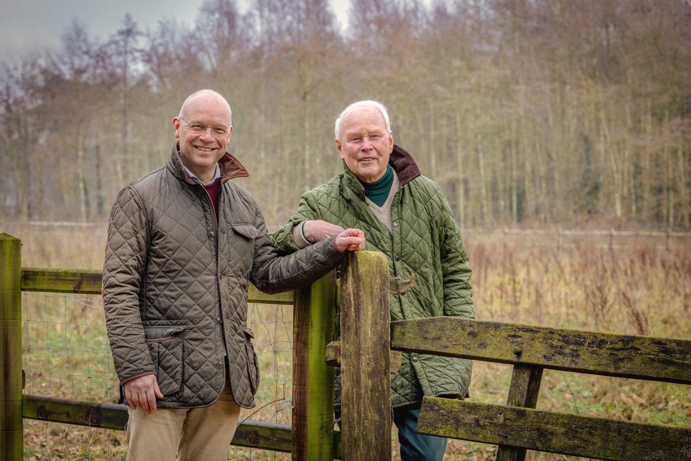 Bram (links) en Frits (rechts) Hulshof bij een hek op hun weiland