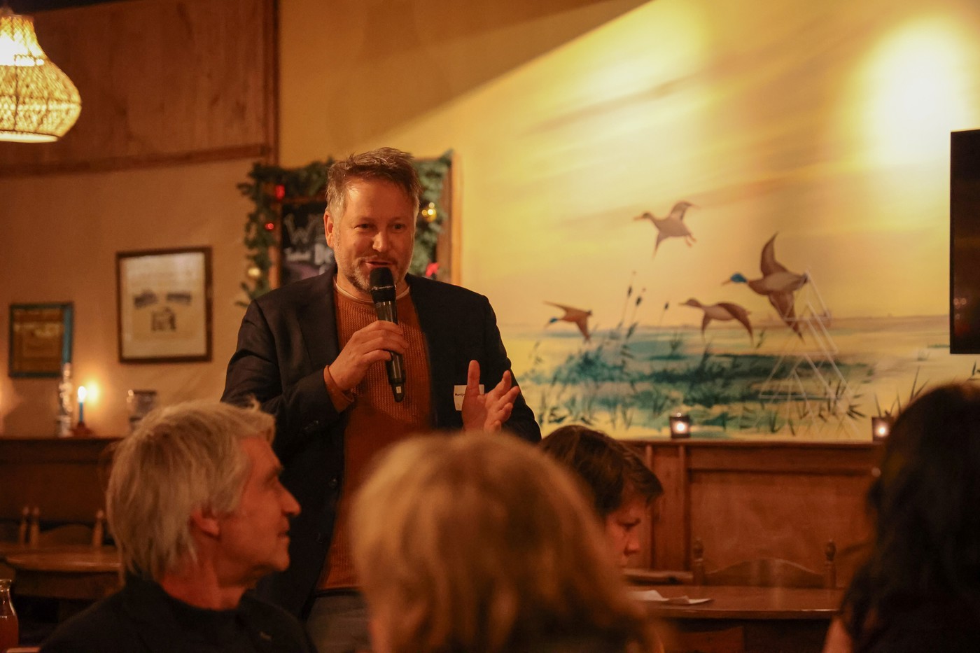 gedeputeerde Martijn Dadema spreekt mensen toe met een microfoon in zijn hand