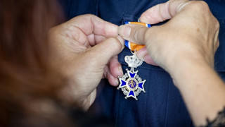 Oranjelintje dat opgespeld wordt op een jasje