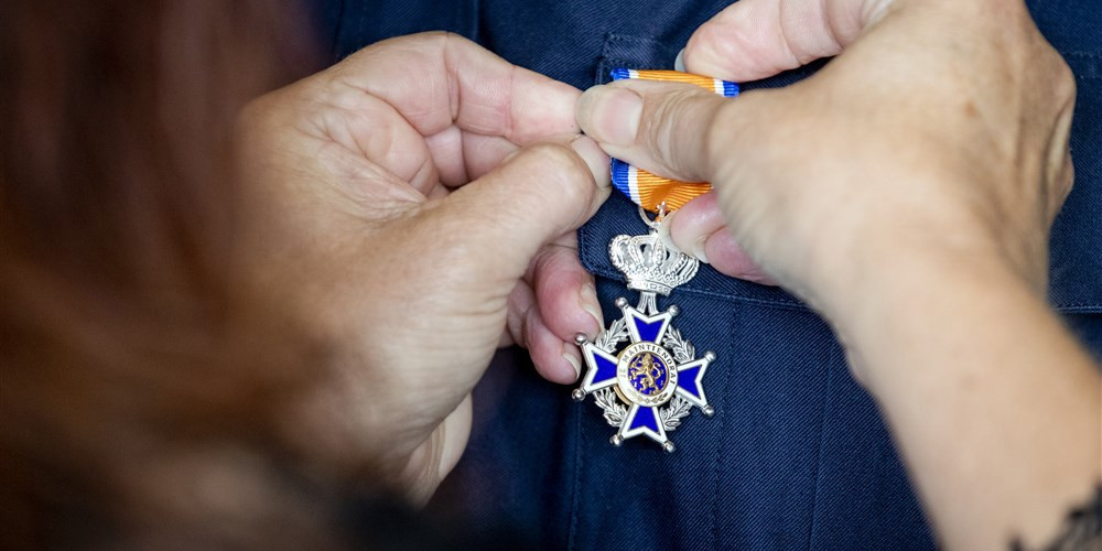 Oranjelintje dat opgespeld wordt op een jasje