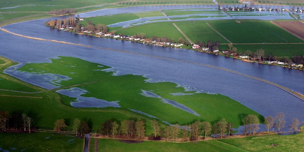 vogelperspectief foto van brede rivier en land dat deels onder water staat tussen landschappen