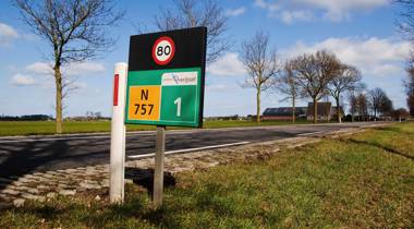Provinciale weg N757 in Overijssel met snelheidsbord 80 km/u en boerderij op de achtergrond.