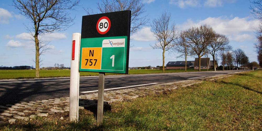 Provinciale weg N757 in Overijssel met snelheidsbord 80 km/u en boerderij op de achtergrond.