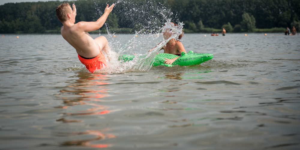 mensen die zwemmen in een natuurlijke plas met krokodil floatie