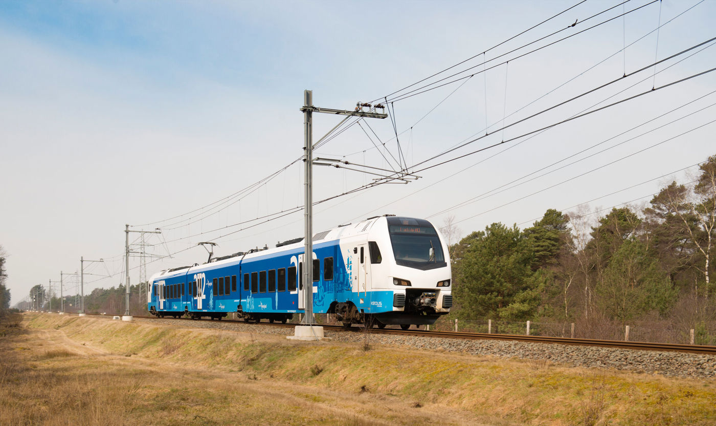 Sprinter die rijdt door landschap langs bomen