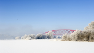 Winterfoto van rode brug in de sneeuw