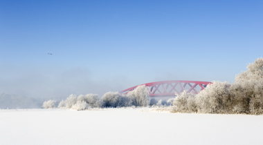 Winterfoto van rode brug in de sneeuw