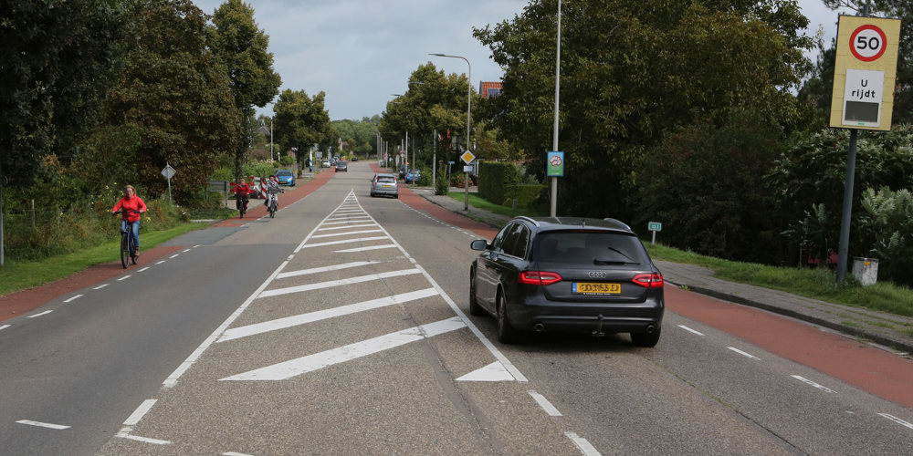 Auto's en fietsers rijden in Den Nul op de N337