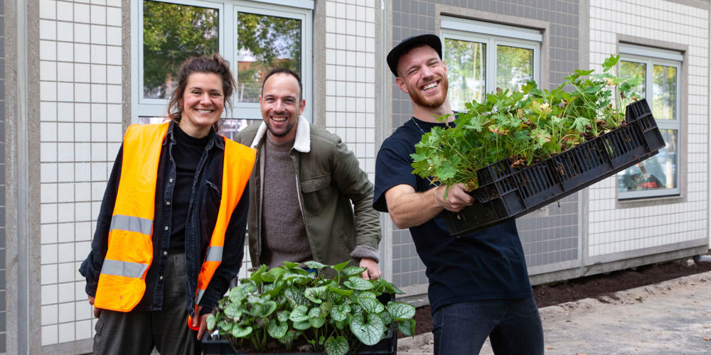 Drie mensen met plantenbakken 