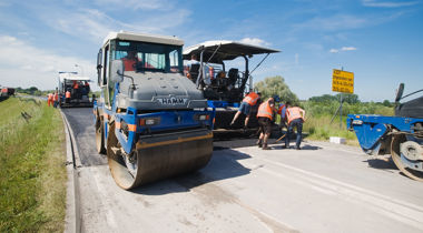Machines die asfalteren op weg met werknemers