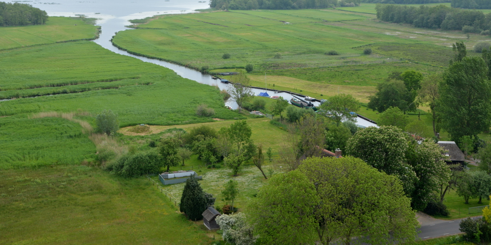 Luchtfoto landschap met sloot ertussen en huisjes