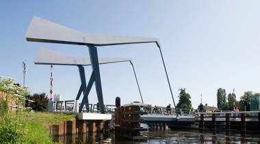 Brug Hoogenweg vanaf de oever gezien op een zonnige dag.