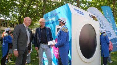 Grote wasmachine van Vitens met mensen eromheen